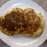 Two corned beef fritters on a plate