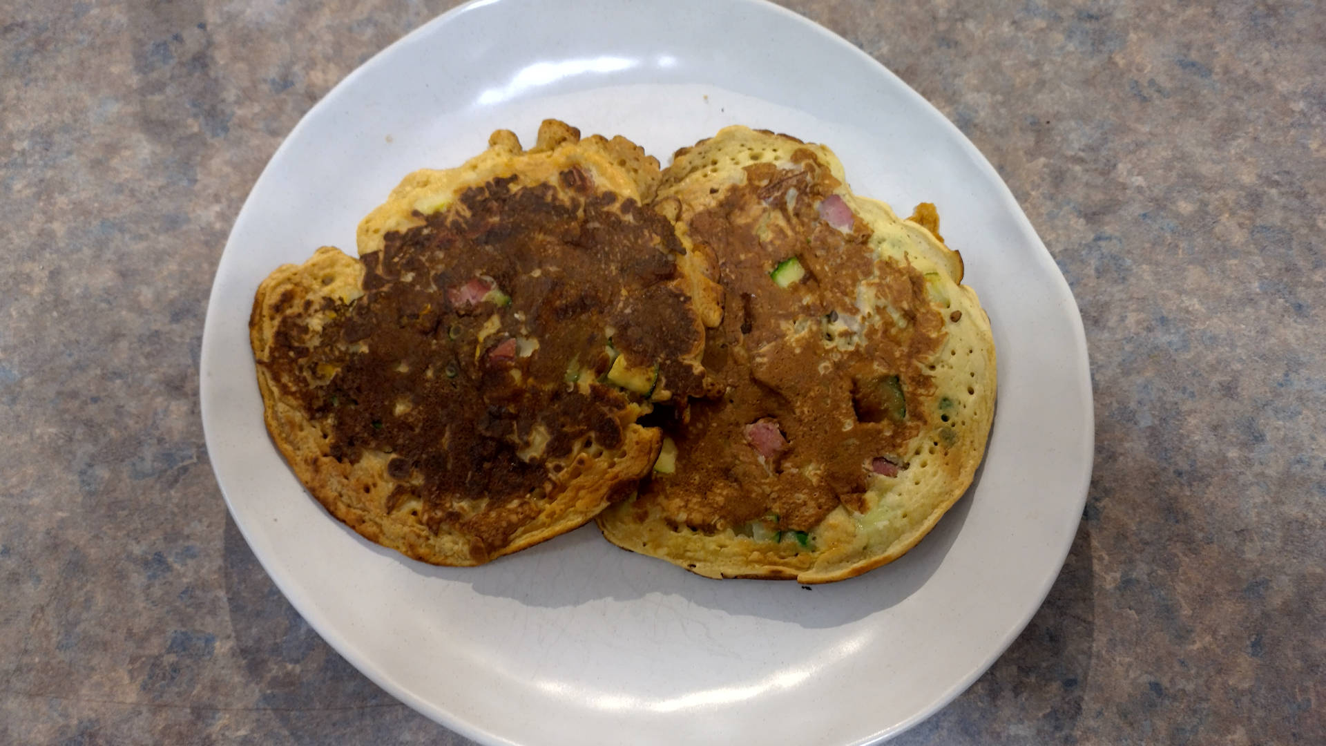 Two corned beef fritters on a plate