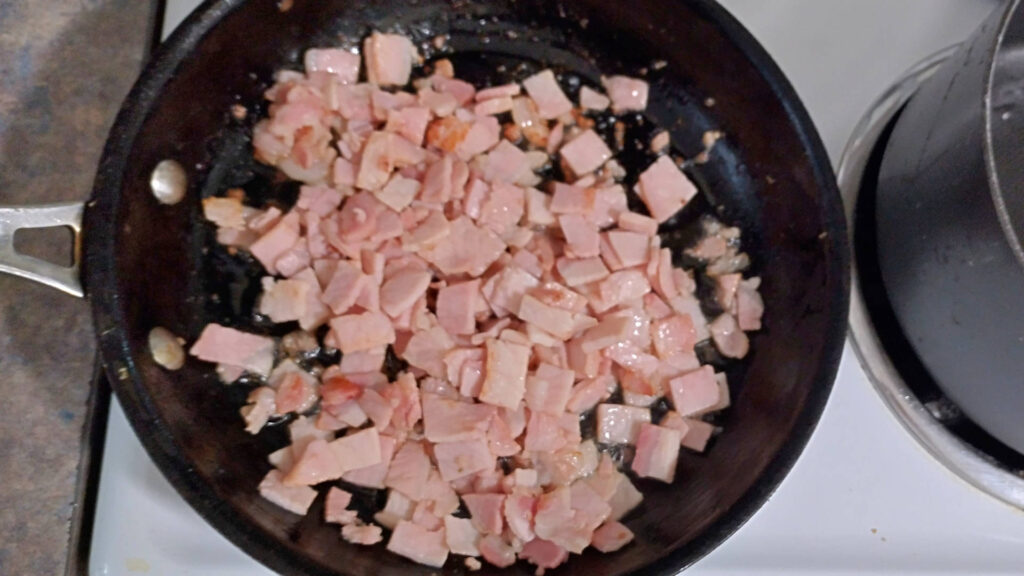 Bacon pieces frying in a pan